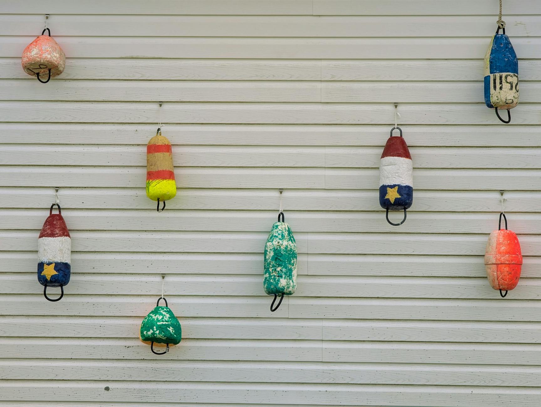 Kolorowe boje rybackie wiszące na białej ścianie w Nowej Szkocji
