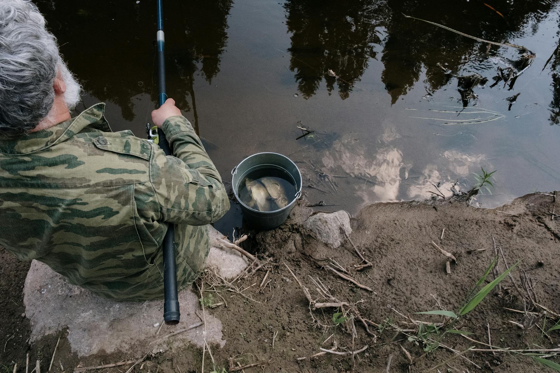 Kiedy leszcz wchodzi na blat i jak to wykorzystać z brzegu Starszy wędkarz nad spokojną rzeką podczas łowienia z brzegu