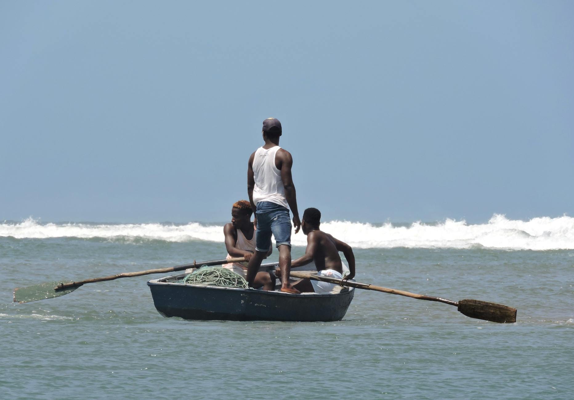 Trzech wędkarzy w łodzi na morzu podczas spokojnego połowu