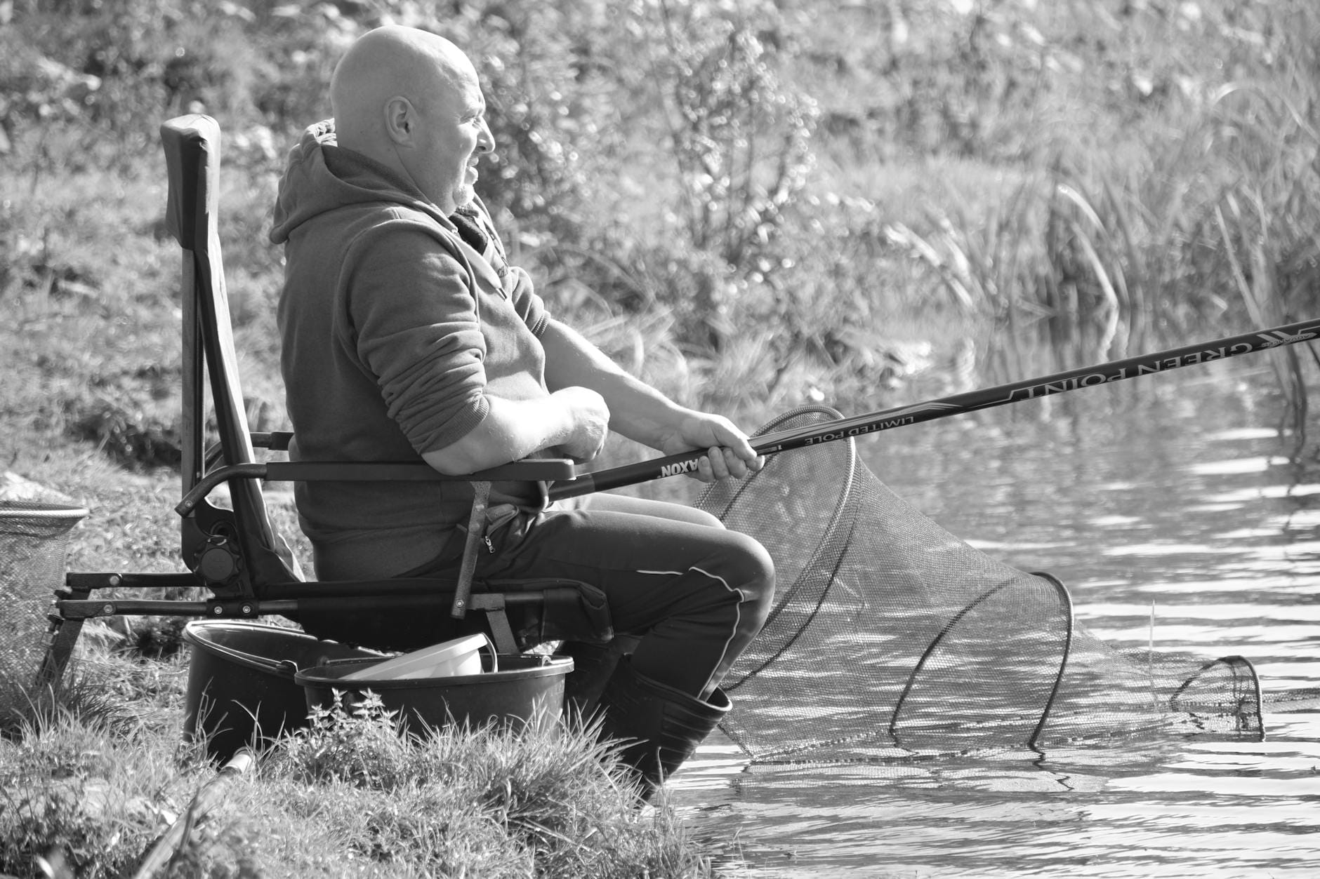 Wędkarz nad spokojną rzeką w słoneczny dzień